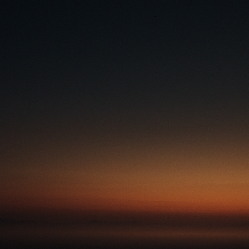 A calm dusk sky fading from deep ink to amber near the horizon